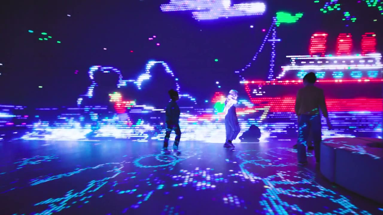Guests walking through a Lite-Brite projection room with cyan rings of light around their feet