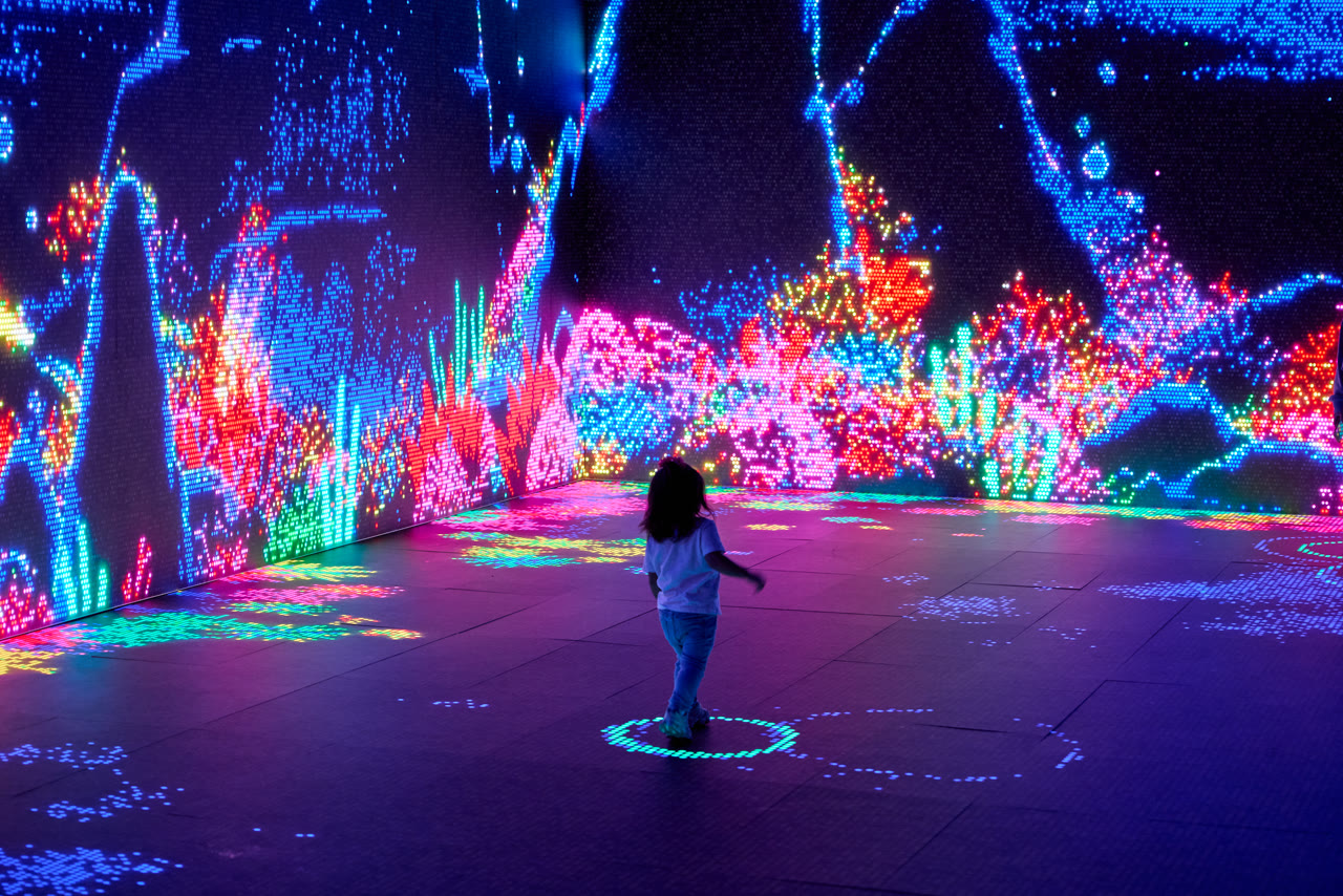A child stands in a huge illuminated ocean scene in the Lite-Brite LED theatre at Santa Monica Place
